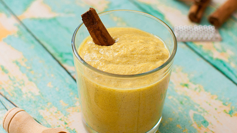 Goldene Milch mit Zimstange im Glas