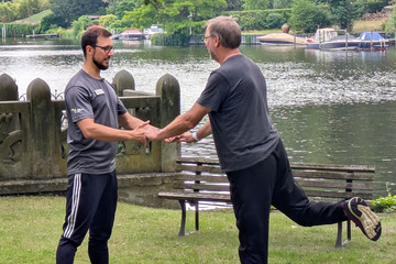 Unter Anleitung von Physiotherapeut Malte Hinrich macht Patient Morgensport Unter Anleitung von Physiotherapeut Malte Hinrich macht Patient Morgensport
