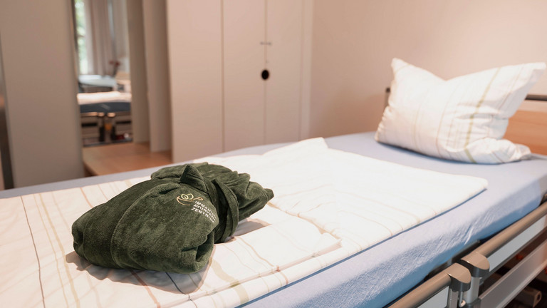 Patientenbett mit Bademantel im Immanuel Ayurveda Zentrum Patientenbett mit Bademantel im Immanuel Ayurveda Zentrum
