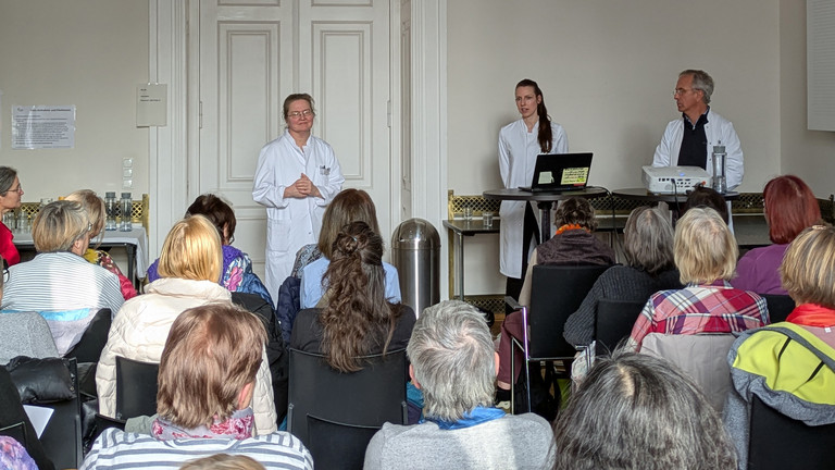 Die drei Referierenden begrüßen das Publikum