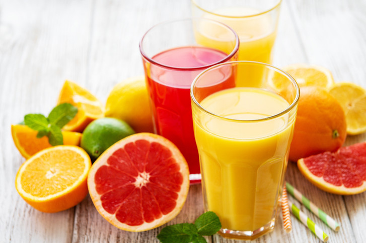 Zitrusfrüchte und Gläser gefüllt mit Saft