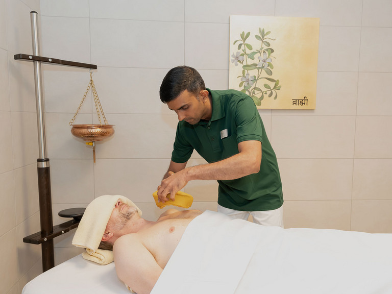 Therapeut legt Teigring auf Patientenbrust - Immanuel Ayurveda Zentrum